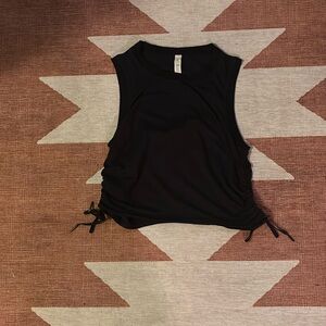 Size 8 Lululemon cropped black workout tank with rouging on the side.
